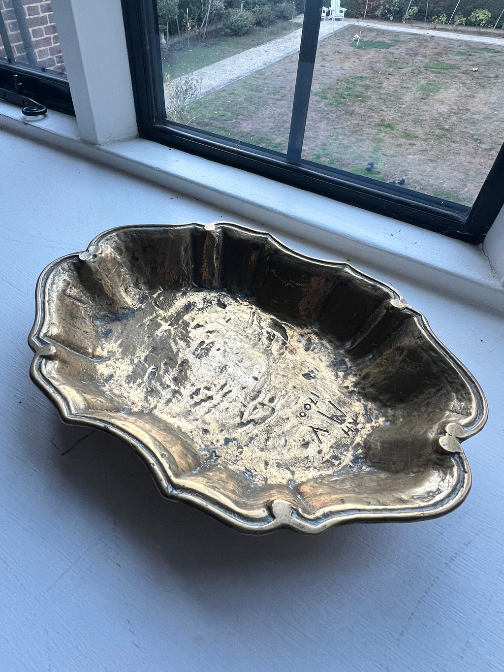 A heavy brass lobe shaped dish with incised initials & date 1700