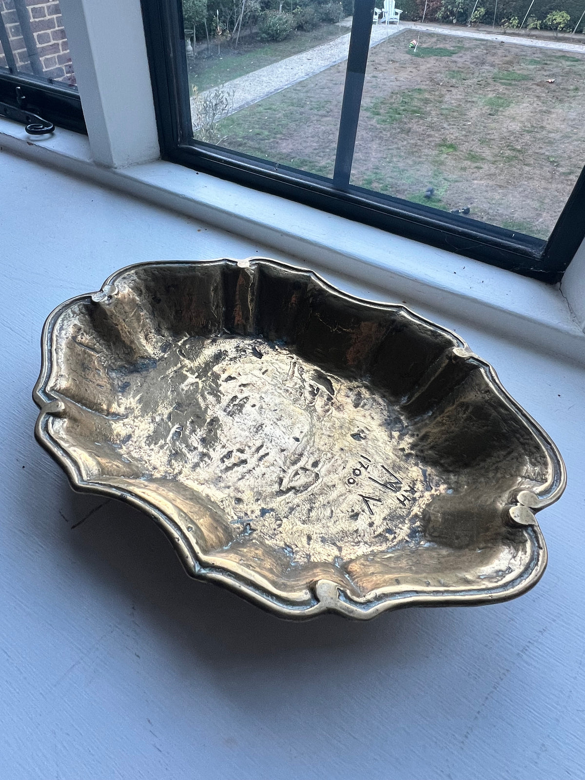 A heavy brass lobe shaped dish with incised initials & date 1700